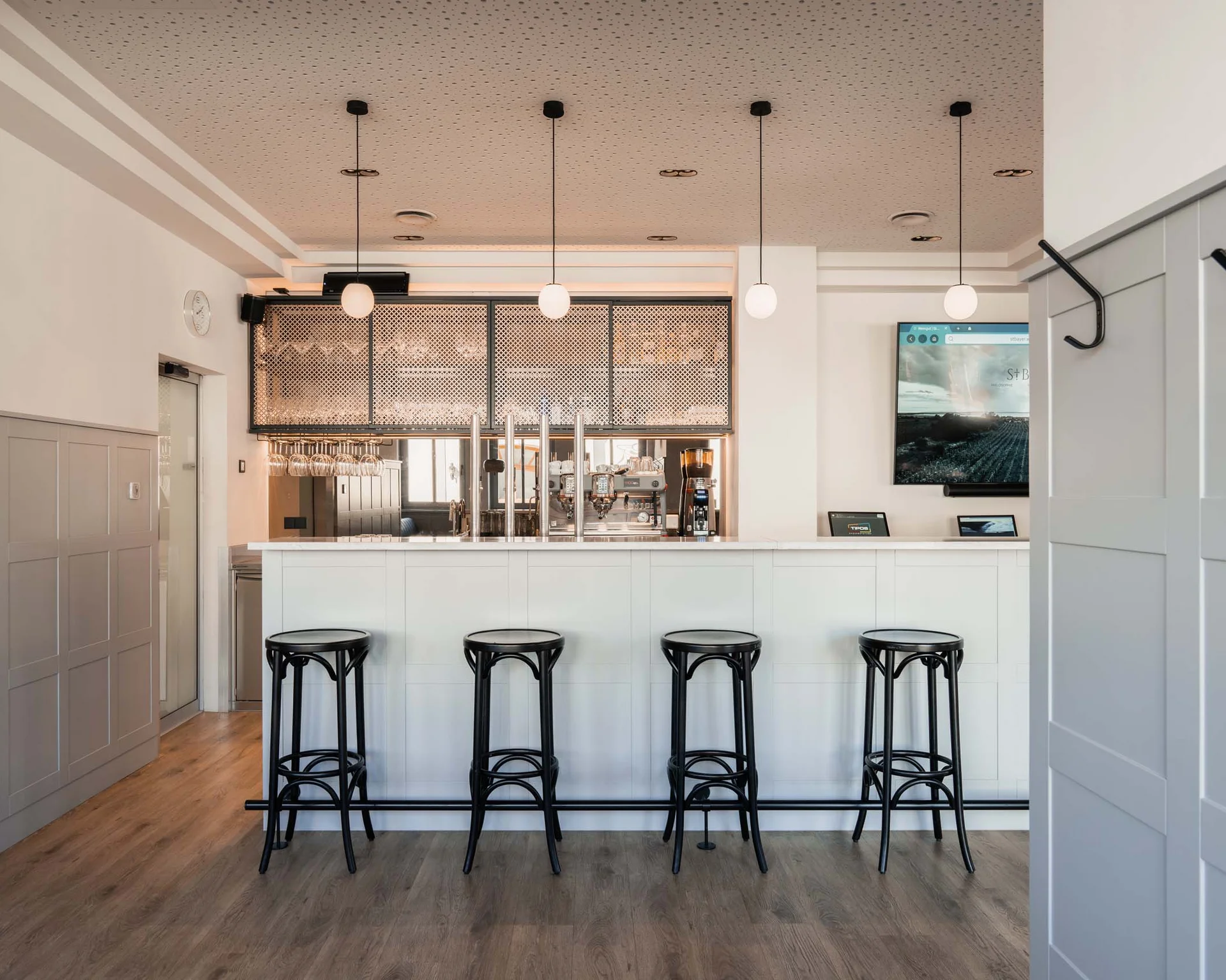 Impressionen aus dem Luis von Weyden Moderner heller Barbereich mit vier schwarzen Barhockern und drei Hängeleuchten