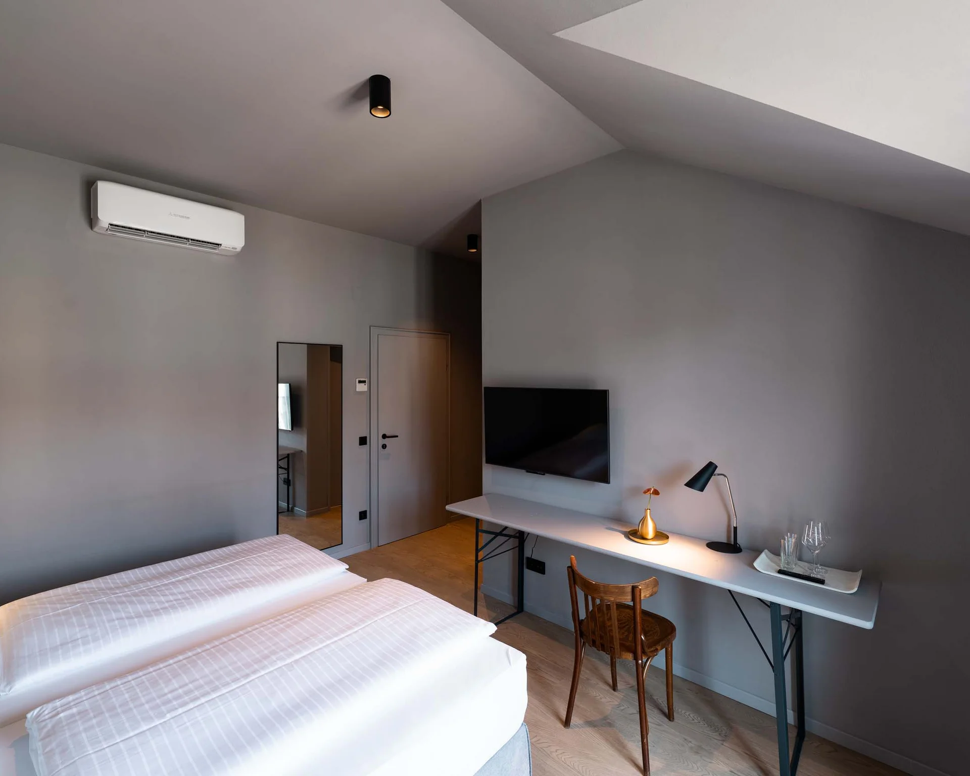 Impressionen aus dem Luis von Weyden Modernes Hotelzimmer mit Doppelbett, Schreibtisch, Fernseher und Klimaanlage