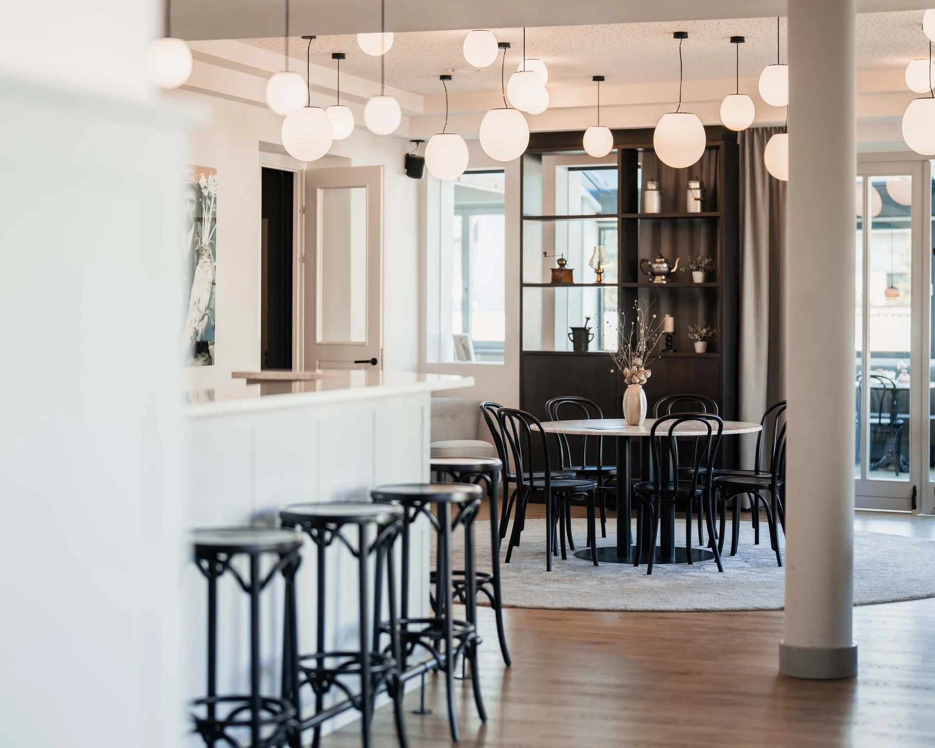 Impressionen aus dem Luis von Weyden Moderner heller Gastraum mit schwarzen Stühlen und rundem Tisch