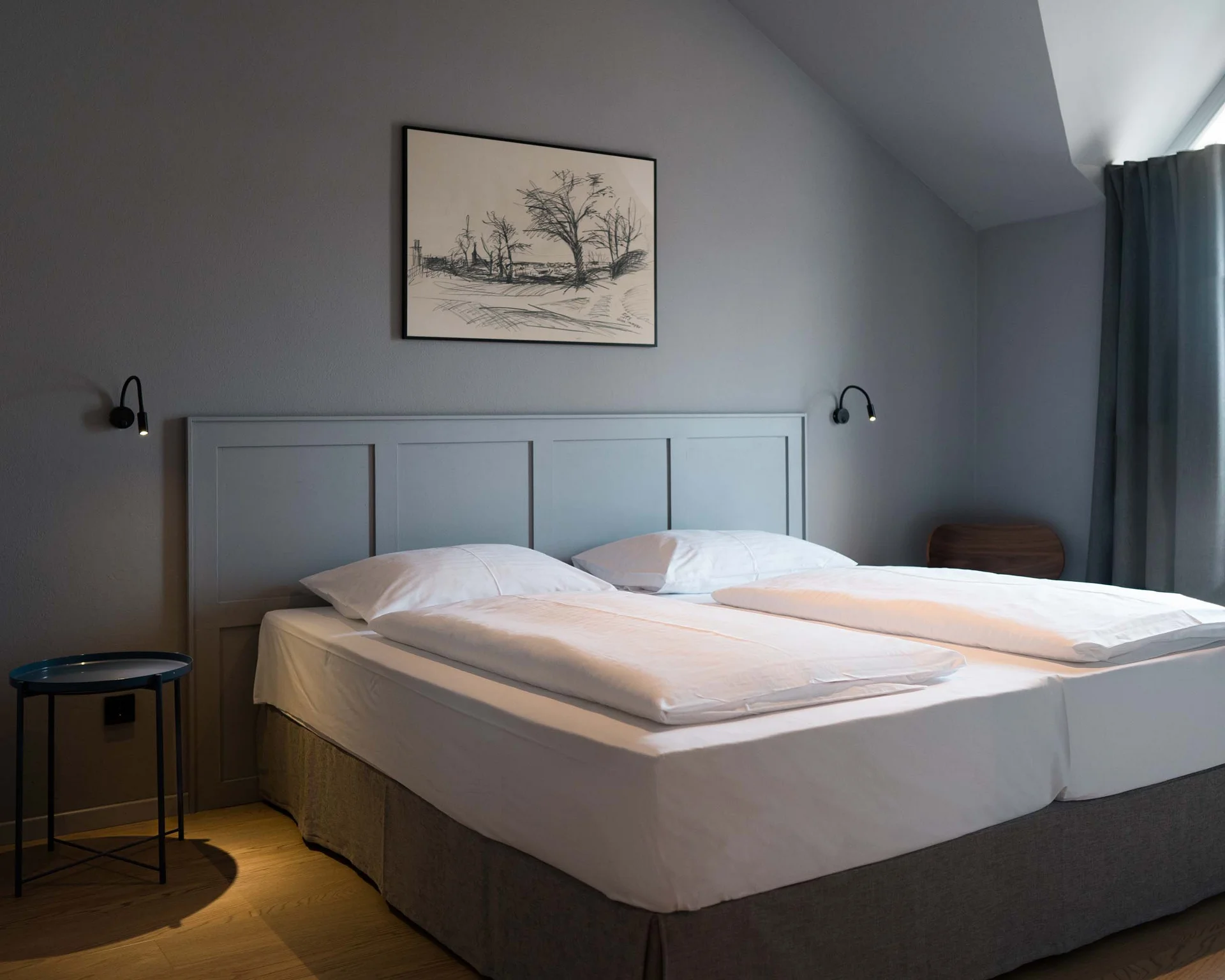 Impressionen aus dem Luis von Weyden Modernes Schlafzimmer mit Doppelbett, grauen Wänden und Holzboden