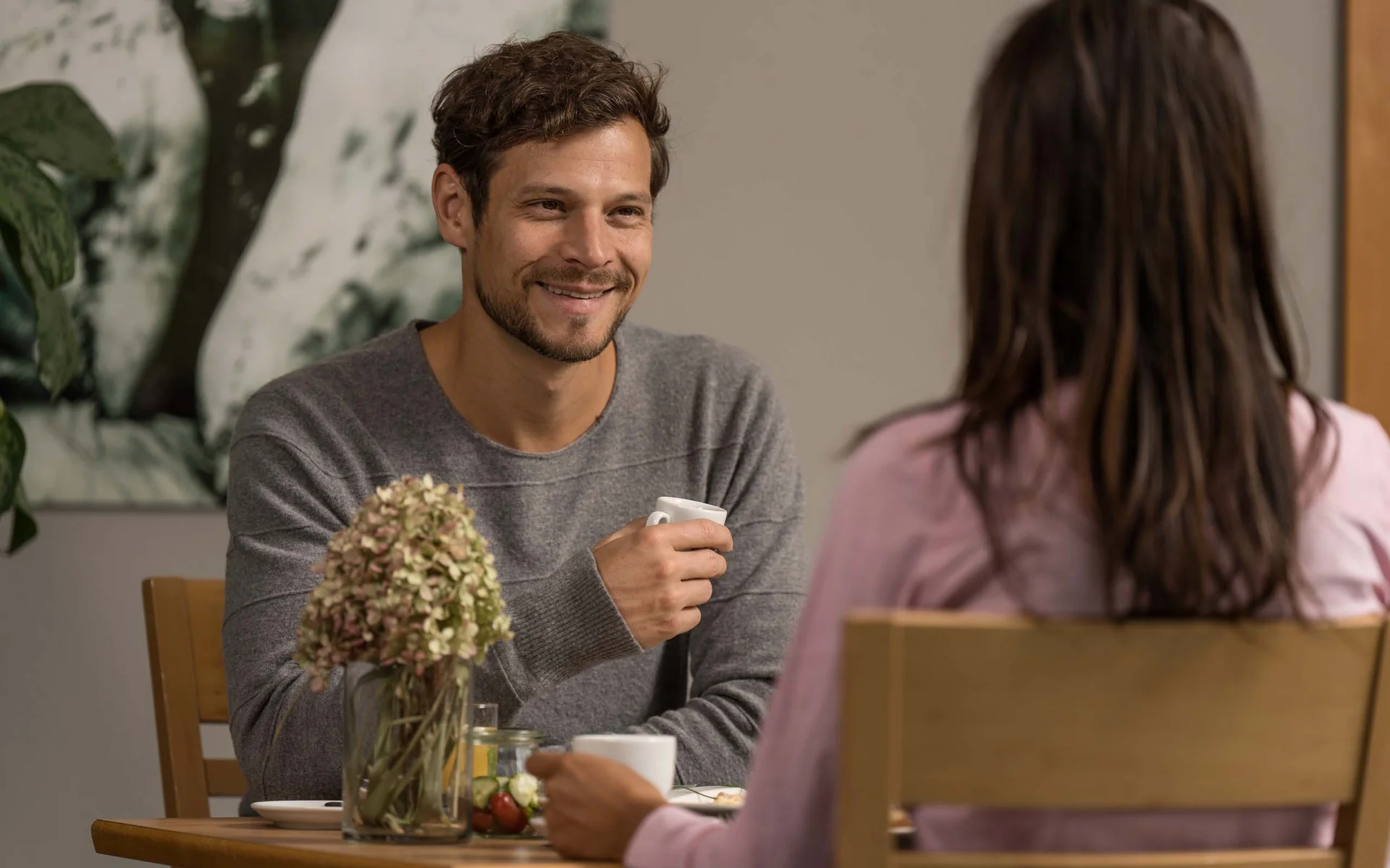 Luis von Weyden: Frühstück in Weiden am See Mann und Frau sitzen am Tisch und trinken Kaffee, unterhalten sich lächelnd