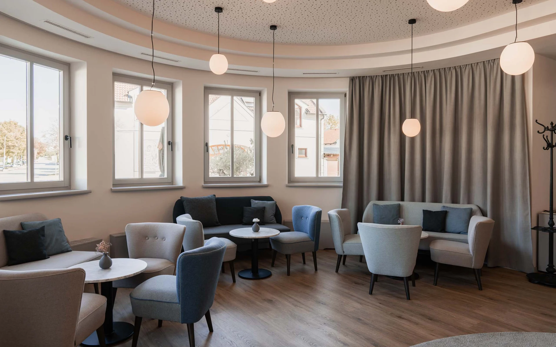Luis von Weyden: die stylishe Pension in Weiden am See Moderner Wartebereich mit Sesseln, Sofas und runden Tischen unter hängenden Lampen