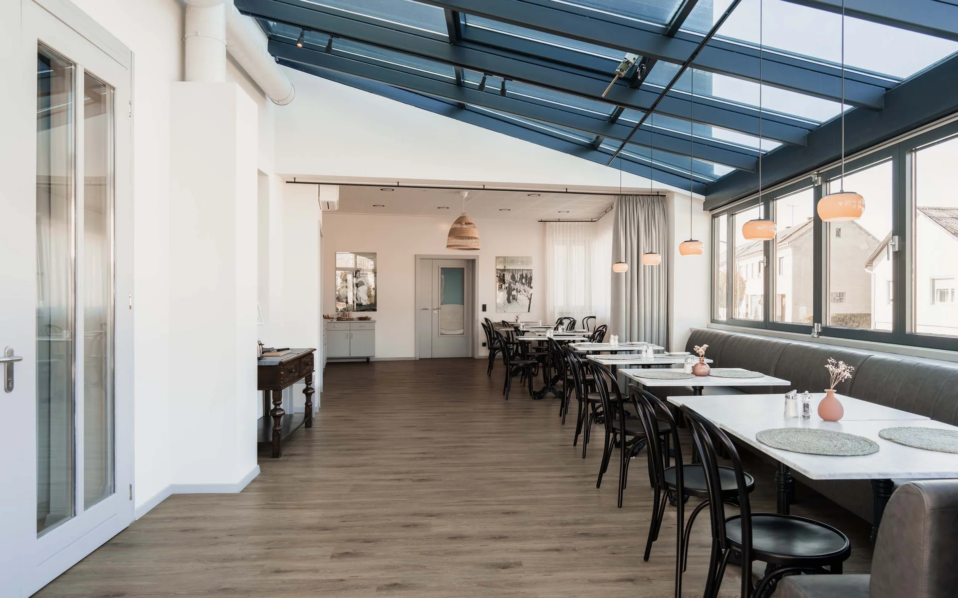 Luis von Weyden: die stylishe Pension in Weiden am See Moderner heller Speiseraum mit Glasdach und Tischen an Fenstern