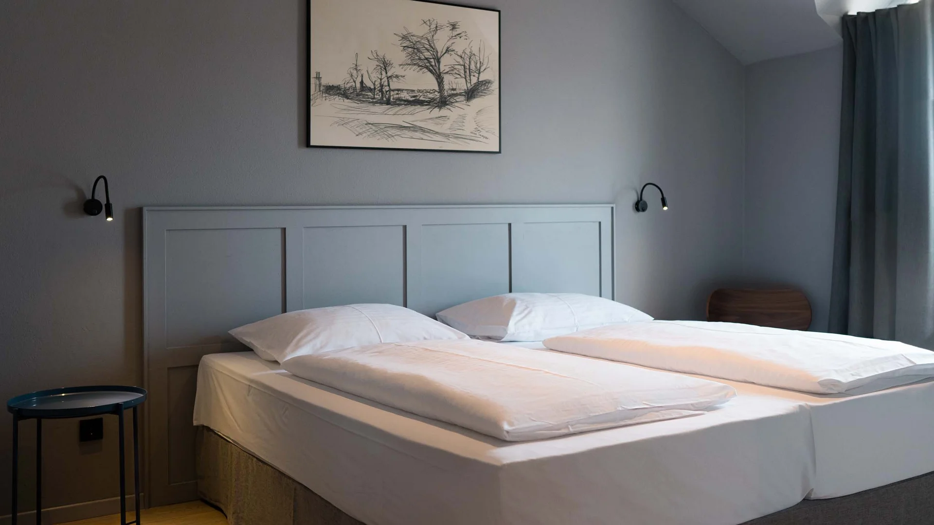 Luis von Weyden: die stylishe Pension in Weiden am See Modernes Schlafzimmer mit Doppelbett, grauen Wänden und Holzboden